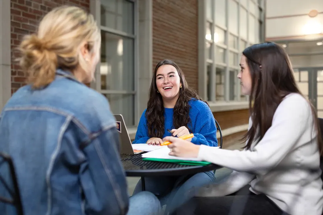 Three students sitting together and talking.